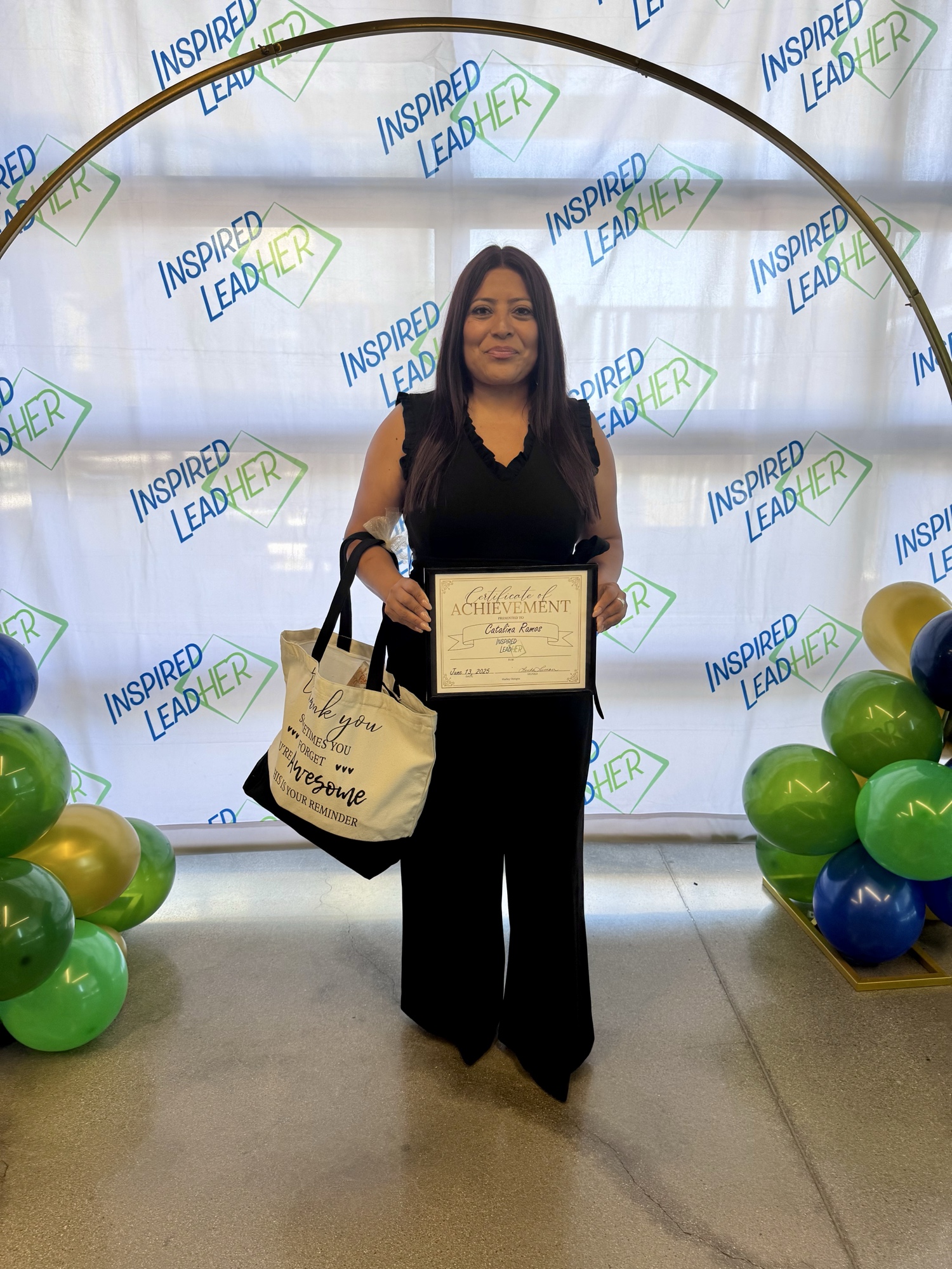 Catalina Ramos holding her 2025 Inspired LeadHER certificate and a Sometimes You Forget You're Awesome tote bag.
