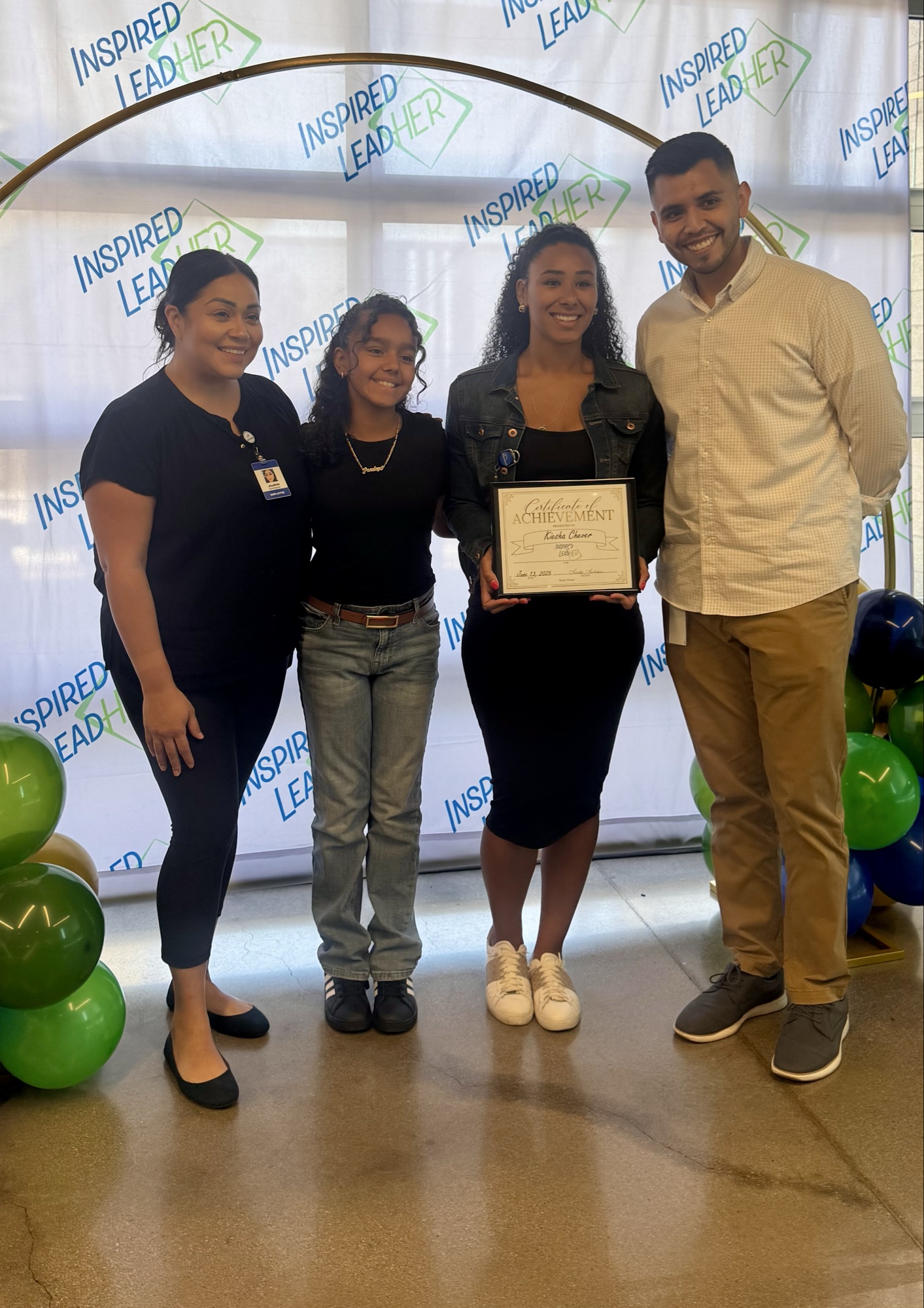 A 2025 Inspired LeadHER graduate posing with a family member while holding her certificate.