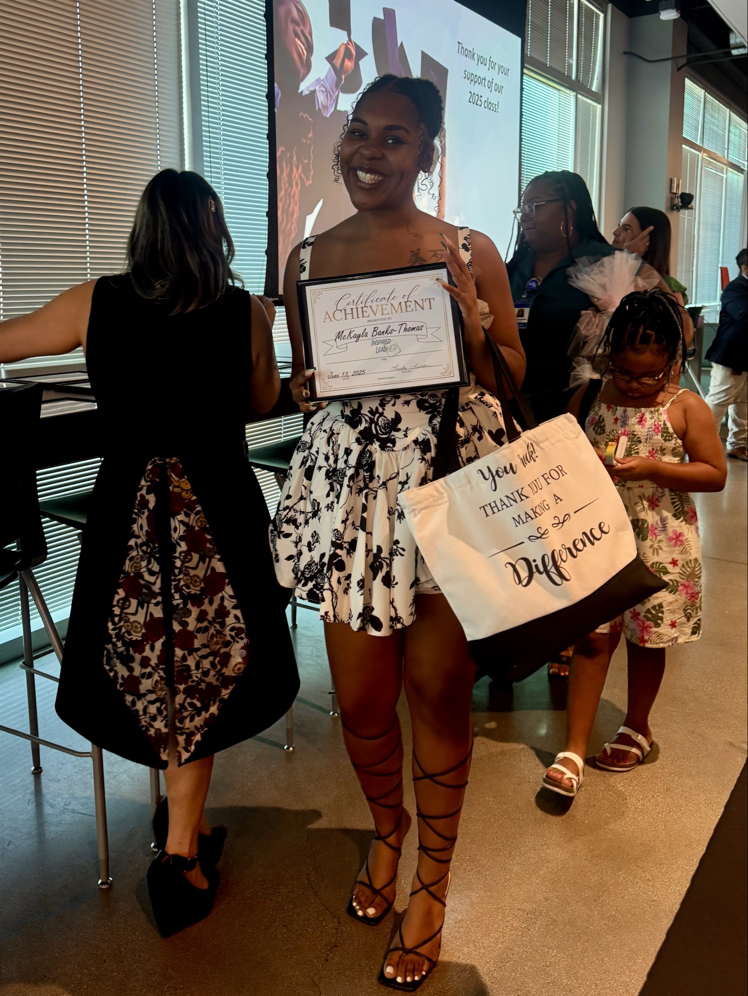 McKayla Banks-Thomas smiling broadly while holding her 2025 Inspired LeadHER Certificate of Achievement.