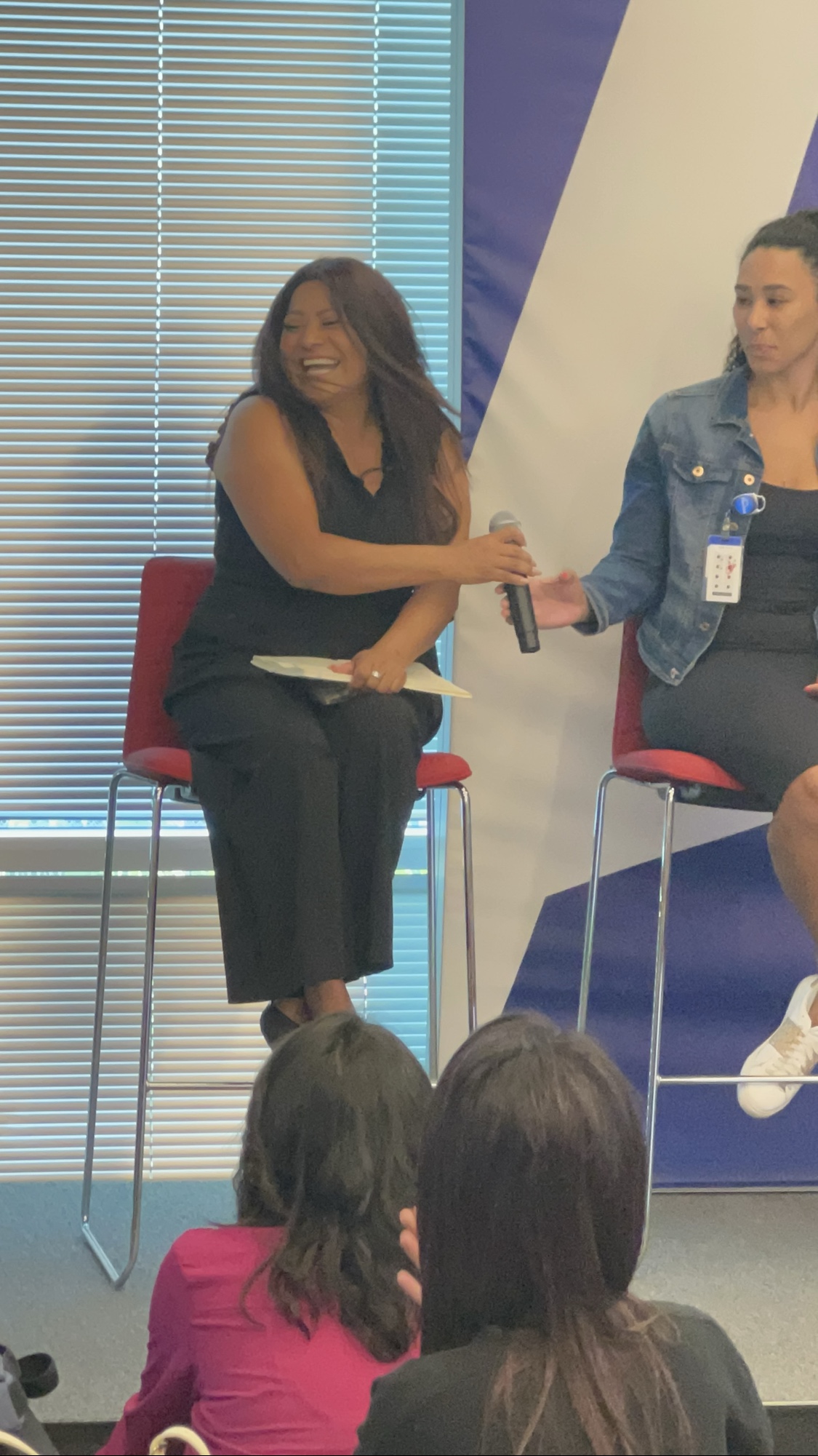 A graduation panelist laughing joyfully during the 2025 Inspired LeadHER closing event.