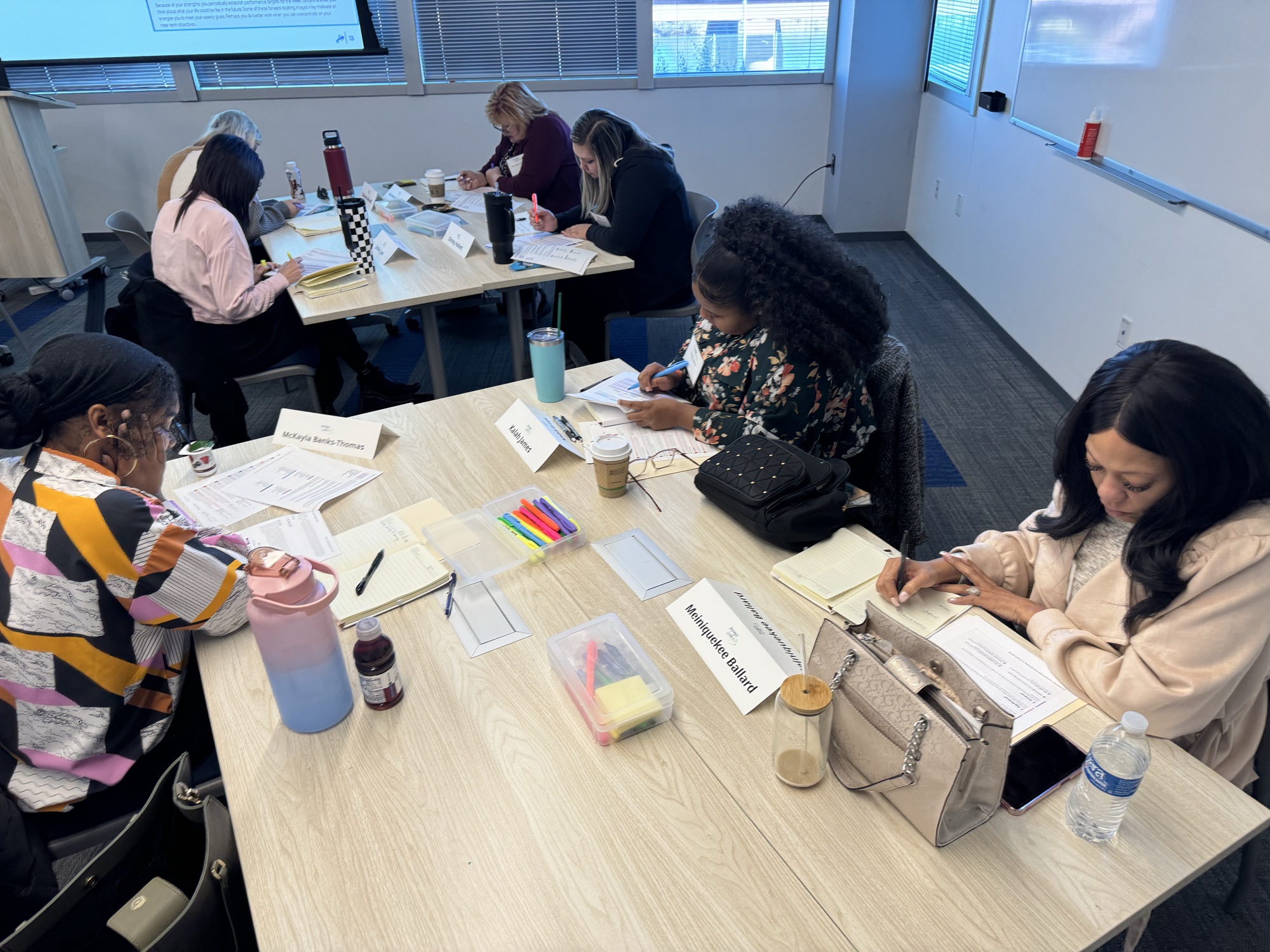 Cohort members working at breakout tables during a 2025 Inspired LeadHER session.