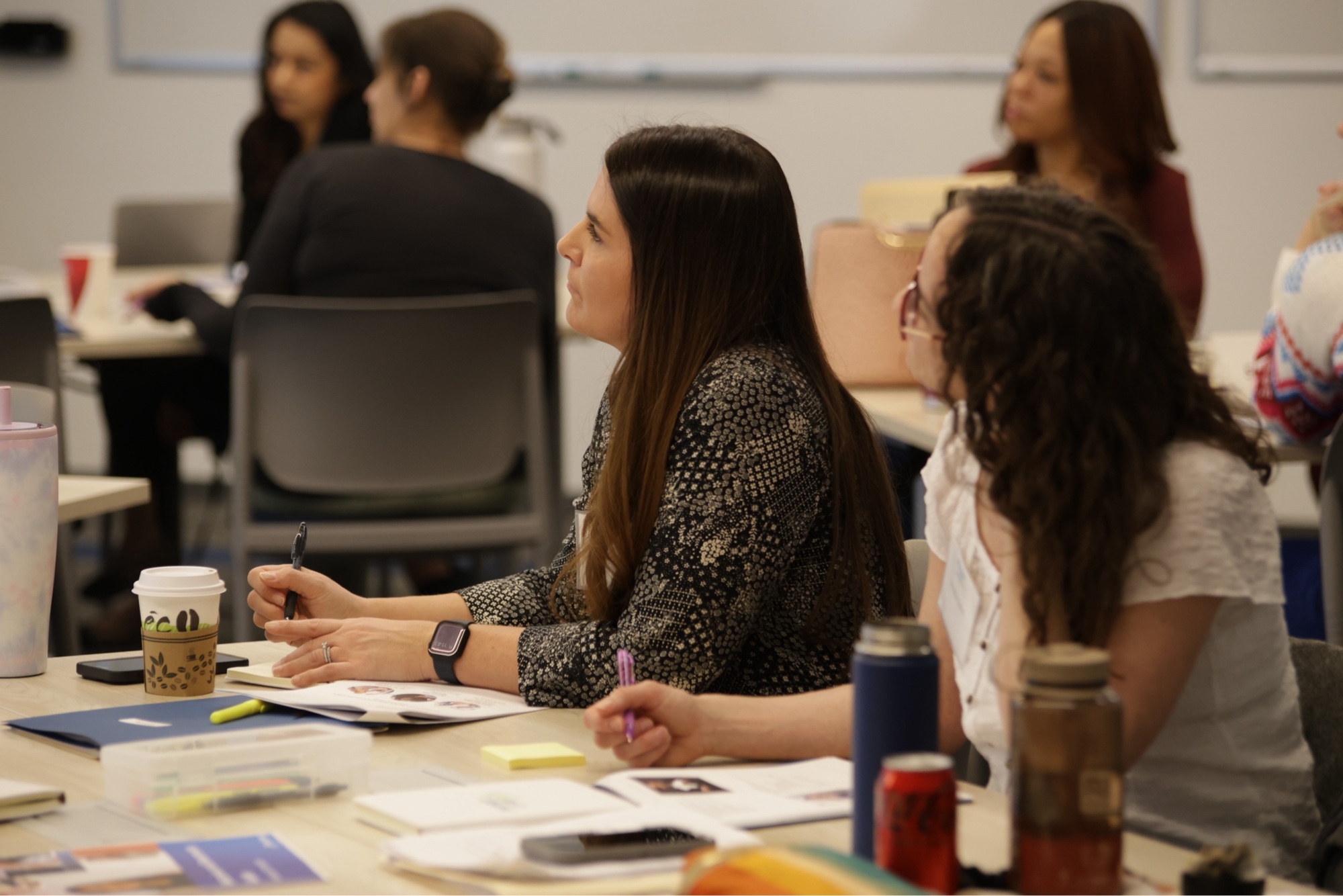 An Inspired LeadHER 2025 cohort participant taking notes and listening intently during a session at the Achieve campus, Tempe AZ.